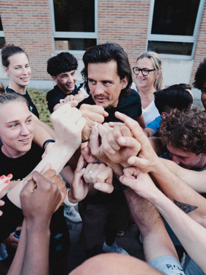 jongeren steken handen bij elkaar